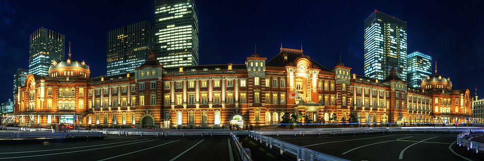 Tokyo Station — ceglana fasada Marunouchi z dwiema kopułami w nocnym oświetleniu. Archiwalna panorama, sprzed przebudowy placu przed stacją.